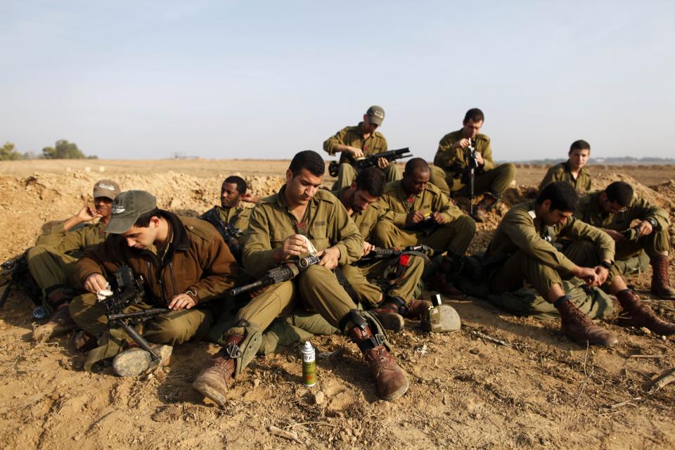 ISRAEL/GAZA BORDER, ISRAEL - NOVEMBER 19: (ISRAEL OUT) Israeli soldiers prepare weapons in a deployment area on November 19, 2012 on Israel's border with the Gaza Strip. The death toll has risen to at least 85 killed in the air strikes, according to hospital officials, on day six since the launch of operation 'Pillar of Defence.' (Photo by Lior Mizrahi/Getty Images)