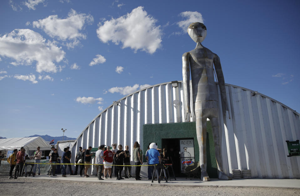 People line up outside of the gift shop at the Storm Area 51 Basecamp event Friday, Sept. 20, 2019, in Hiko, Nev. The event was inspired by the "Storm Area 51" internet hoax. Thousands of curious Earthlings from around the globe traveled to festivals, and several hundred made forays toward the secret Area 51 military base in the Nevada desert on Friday, drawn by an internet buzz and a social media craze sparked by a summertime Facebook post inviting people to “Storm Area 51.” (AP Photo/John Locher)