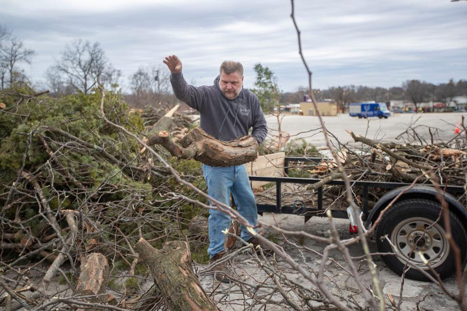 Brian Dougherty, owner of Angel Handyman, empties a trailer full of limbs on Monday, April 3, 2023, in Rockford.