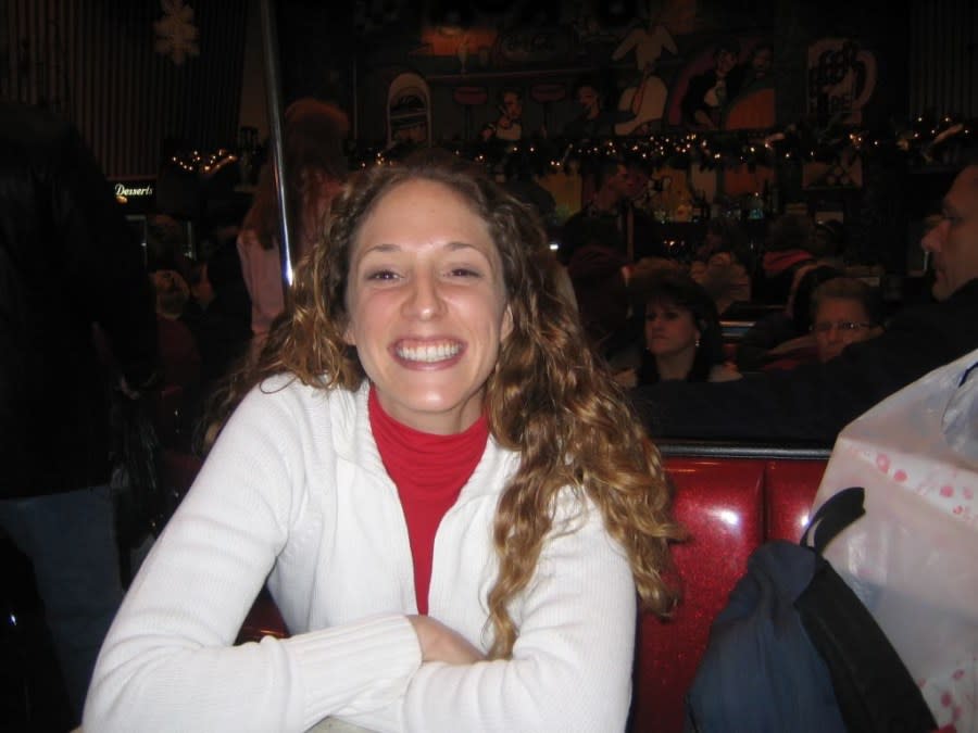 A woman smiles at a table