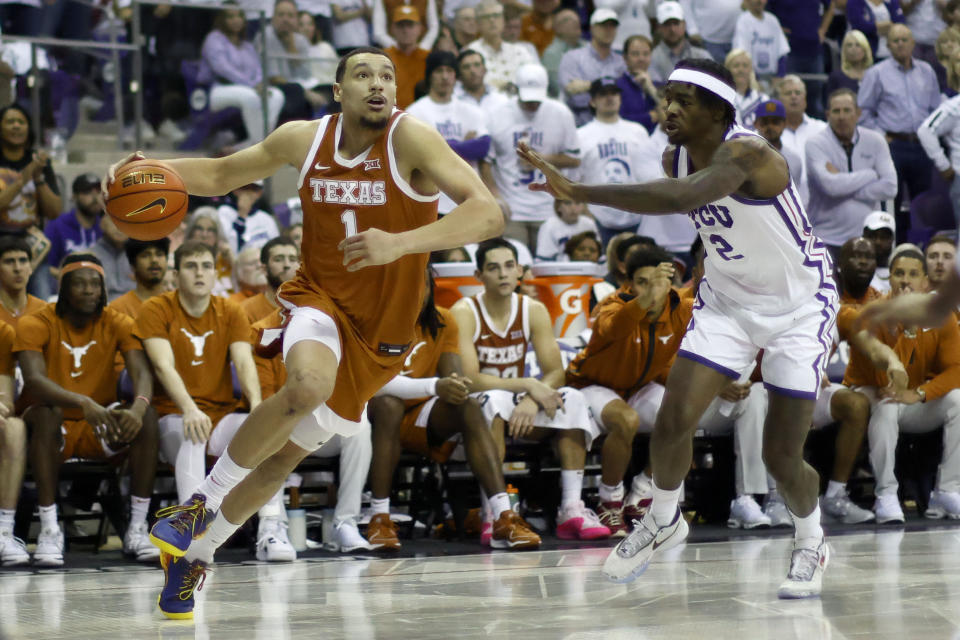 Texas forward Dylan Disu (1) drives to the basket against TCU forward Emanuel Miller (2) during the second half of an NCAA college basketball game in Fort Worth, Texas, Saturday, Feb. 3, 2024. (AP Photo/Michael Ainsworth)