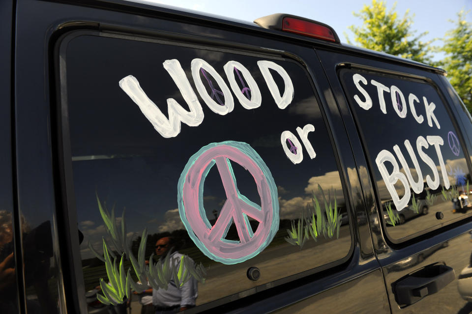 FILE - This Aug. 14, 2009 file photo shows a van decorated with "Woodstock or Bust" at the original Woodstock Festival site in Bethel, N.Y. The Woodstock 50 festival is back on after a court on Wednesday, May 15, 2019 rebuffed an ex-investor’s effort to cancel the anniversary extravaganza. But organizers will have to do without some $18 million, at least for now. (AP Photo/Stephen Chernin, File)