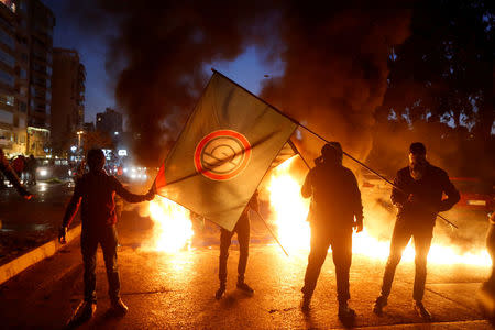 Supporters of Amal movement hold the party's flag near burning tires in Beirut, Lebanon January 29, 2018. REUTERS/Mohamed Azakir