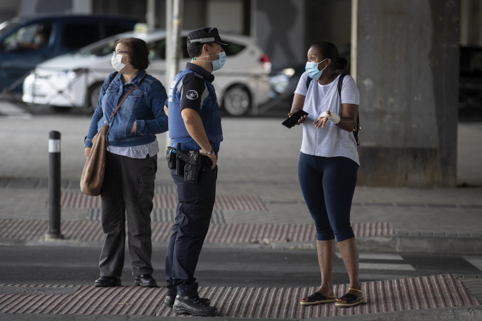 A local police officer talks with a woman at a checkpoint in the Vallecas neighborhood in Madrid, Spain, on Wednesday. (Photo: ASSOCIATED PRESS)