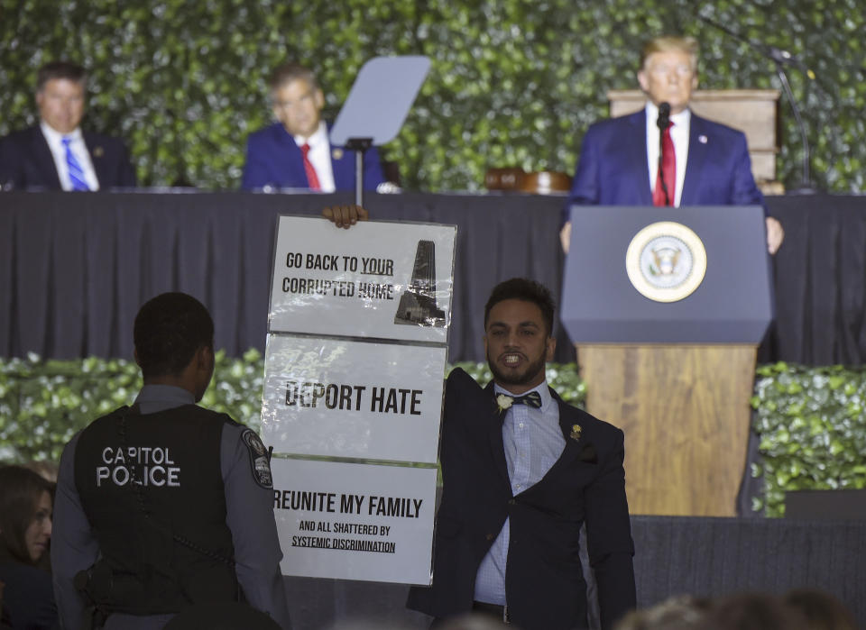 Virginia State Delegate Ibraheem Samirah holds a sign as President Trump speaks in Jamestown, Va., on July 30. (Photo: Andrew Caballero-Reynolds/AFP/Getty Images)