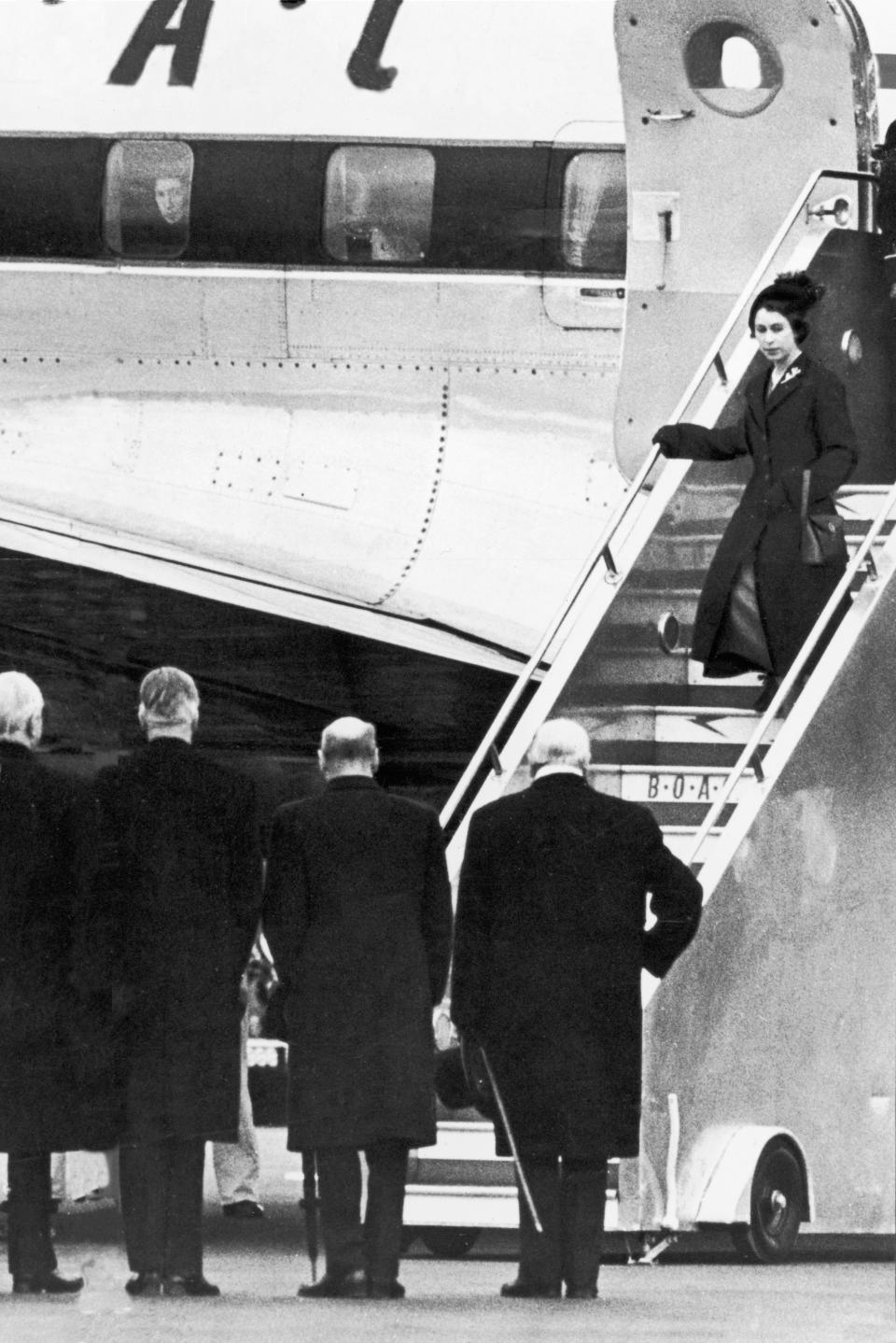 Queen Elizabeth II walks down the steps airplane at London Airport (now Heathrow) after death of her father King George