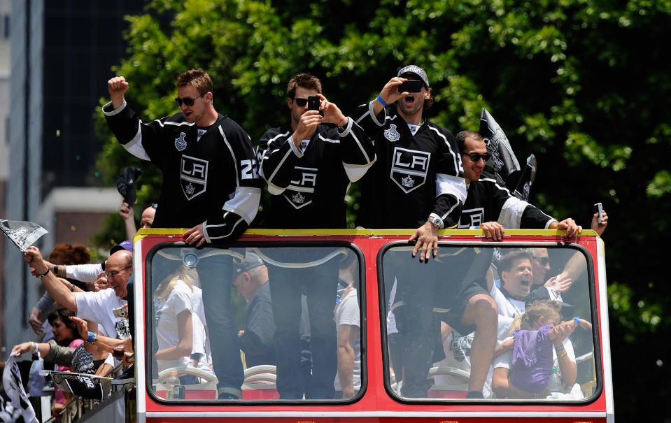 LOS ANGELES, CA - JUNE 14: Los Angeles Kings team members from left Trevor Lewis #22, Brad Richardson #15 and Jarret Stoll #28 wave to cheering fans during the Stanley Cup victory parade on June 14, 2012 in Los Angeles, California. The Kings are celebrating their first NHL Championship in the team's 45-year-old franchise history. (Photo by Kevork Djansezian/Getty Images)