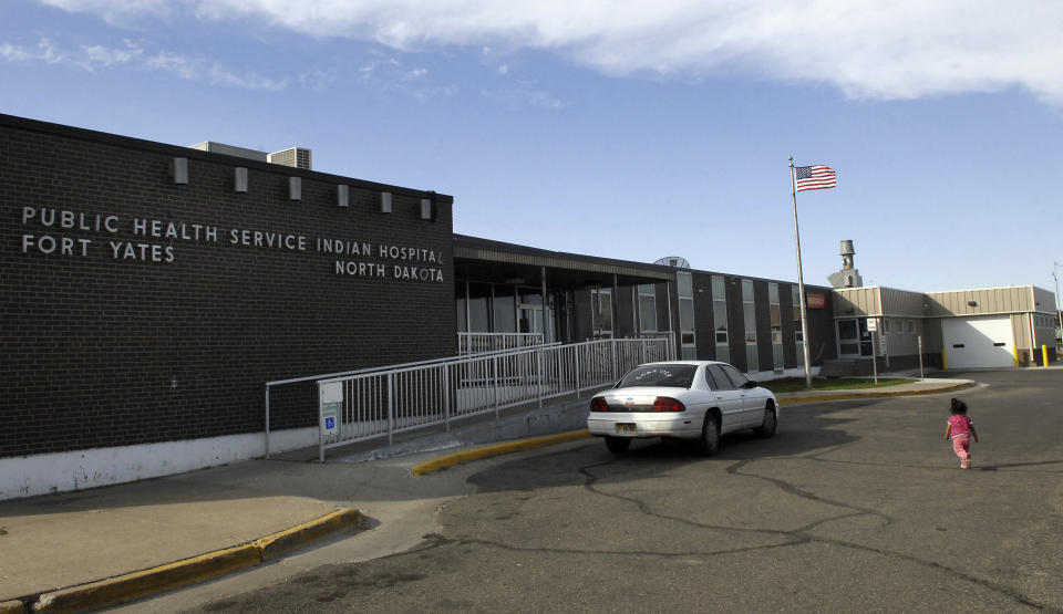 FILE - In this Oct. 14, 2008, a small child walks toward the front door of the Public Health Service Indian Hospital on the Standing Rock Reservation in Fort Yates. N.D. A federal audit released Monday, July 22, 2019, finds that government hospitals placed Native Americans at increased risk for opioid abuse and overdoses. The audit says a handful of Indian Health Service hospitals, including the Fort Yates Hospital, failed to follow the agency’s protocols for dispensing and prescribing the drug. The Indian Health Service agreed with the more than a dozen recommendations and says changes are in the works. (AP Photo/Will Kincaid, File)