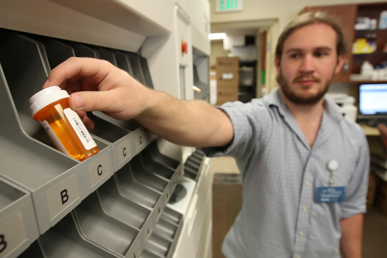 Pharmacy technician McKay Kleinman, holds a filled prescription bottle that came out from an automated drug dispensing machine at the Rock Canyon pharmacy in Provo, Utah, U.S., May 9, 2019.  REUTERS/George Frey