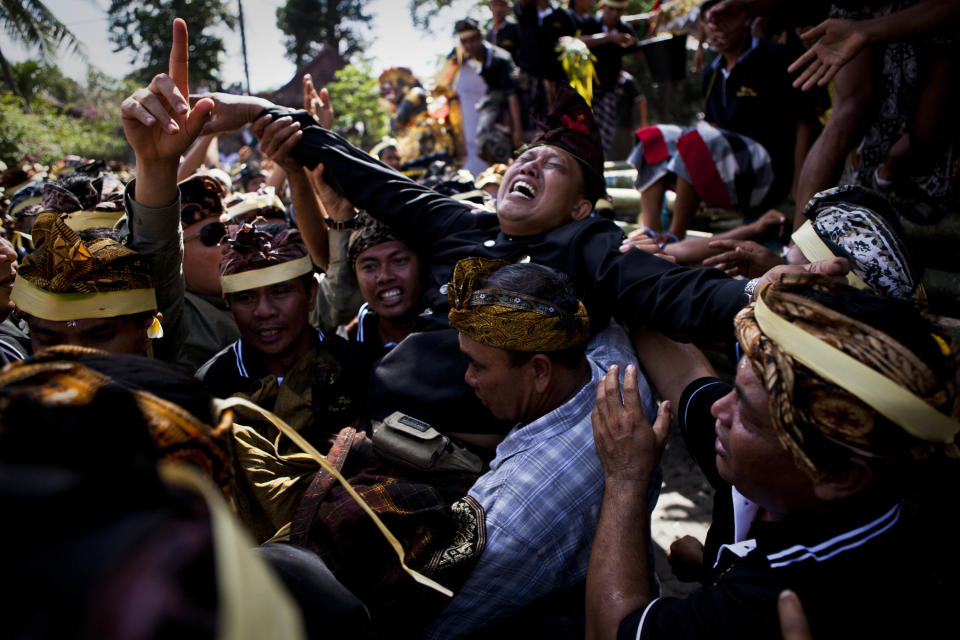 UBUD, BALI, INDONESIA - AUGUST 18: A son of Anak Agung Rai Niang mourns is carried down from the cremation tower, during the Hindu Royal cremation - also know as the Pengabenan - for the late Anak Agung Niang Rai, mother of Gianyar Regent, Tjokorda Oka Artha Ardana Sukawati, at Puri Ubud in Gianyar Bali on August 18, 2011 in Ubud, Bali, Indonesia. Niang Rai died in a Denpasar hospital in May; and will involve a nine level, 24m high 'bade' or body carring tower, made by upto 100 volunteers from 14 local villages. It will be carried to the cremation by 4500 Ubud residents. (Photo by Ulet Ifansasti/Getty Images)