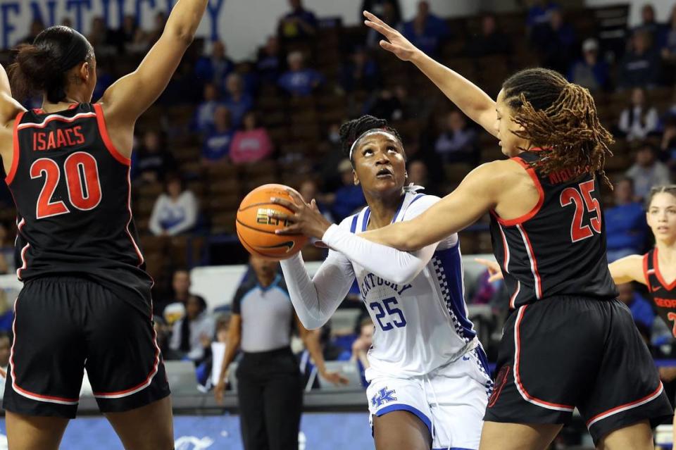 Kentucky’s Adebola Adeyeye (25) looks for an opening between Georgia’s Jordan Isaacs (20) and Kari Niblack (25) during a game at Memorial Coliseum on Feb. 16.