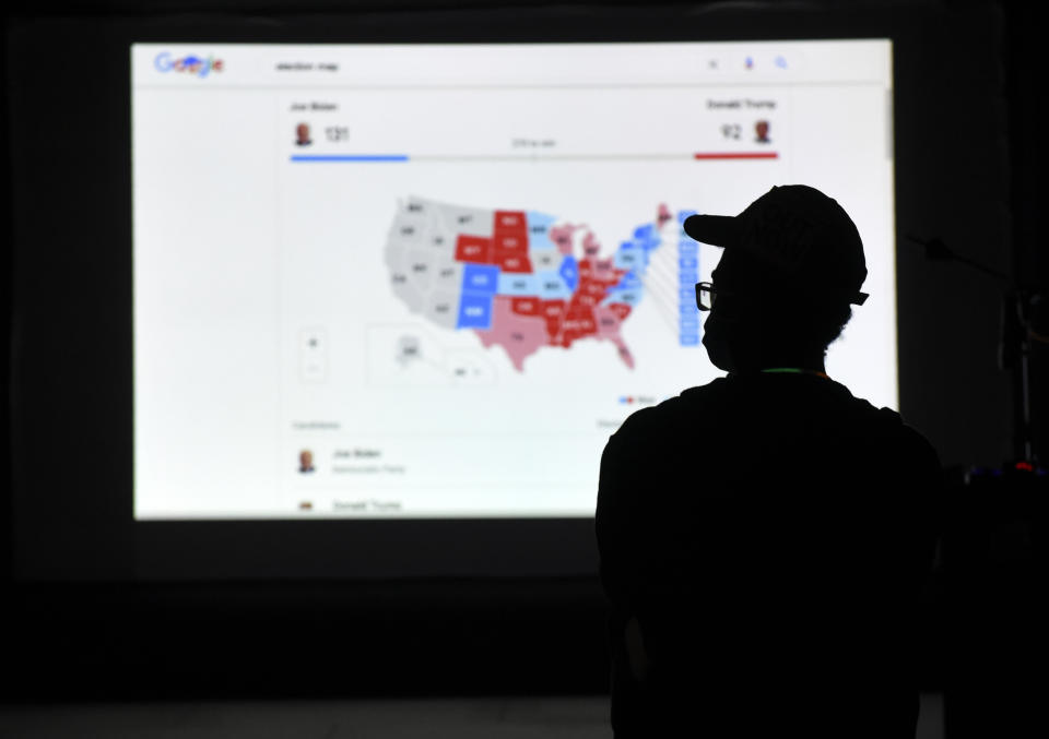 FIE - A man watches results come in on a screen set up at an election night gathering at Independence Mall, Nov. 3, 2020, in Philadelphia. (AP Photo/Michael Perez, File)