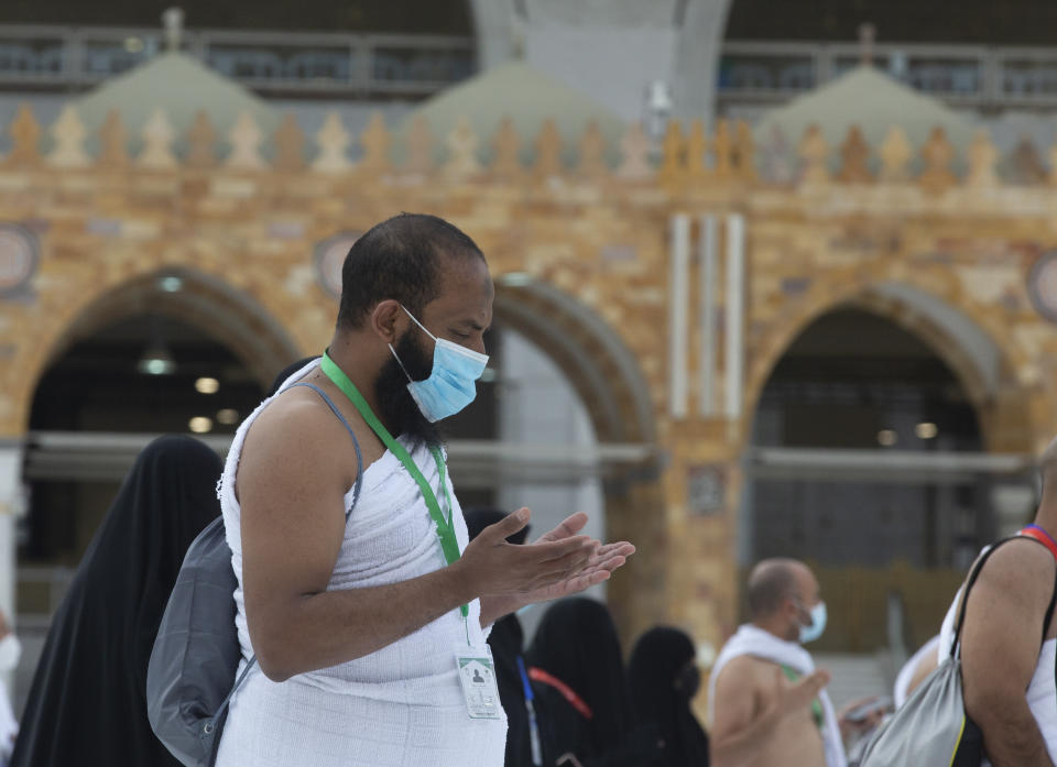 A Muslim pilgrim prays in front of the the Kaaba, the cubic building at the Grand Mosque, as he wears a mask and keeps social distancing, a day before the annual hajj pilgrimage, Saturday, July 17, 2021. The pilgrimage to Mecca required once in a lifetime of every Muslim who can afford it and is physically able to make it, used to draw more than 2 million people. But for a second straight year it has been curtailed due to the coronavirus with only vaccinated people in Saudi Arabia able to participate. (AP Photo/Amr Nabil)