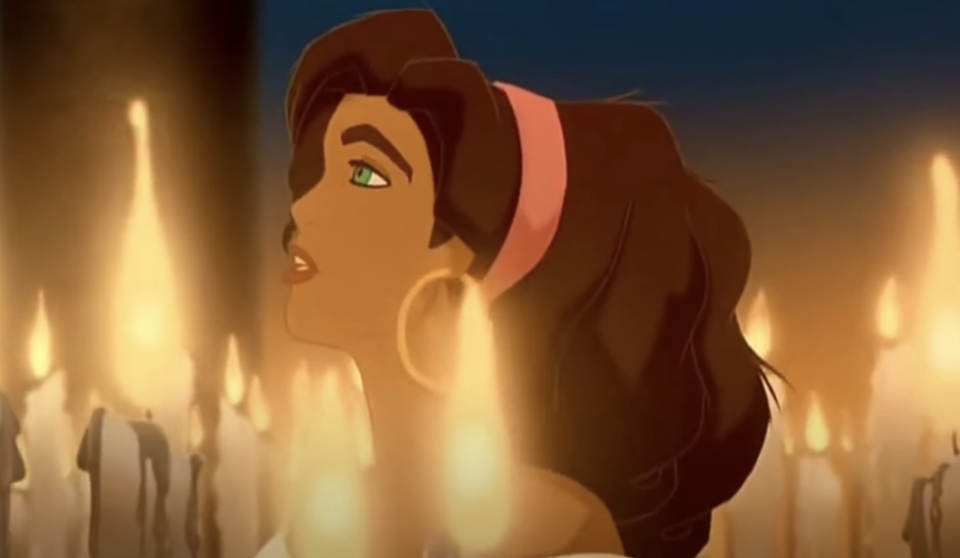 Esmeralda walking by candles and singing