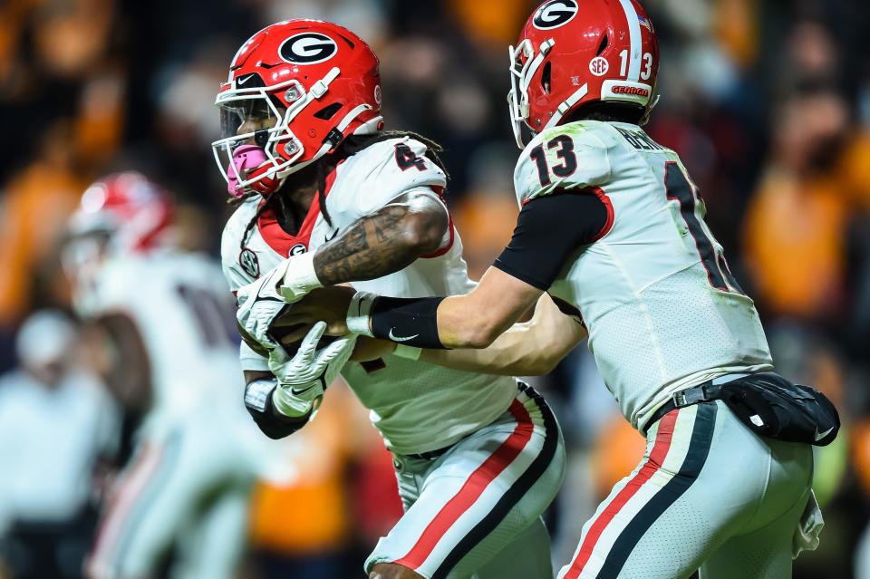 Georgia running back James Cook (4) takes a hand off from quarterback Stetson Bennett.