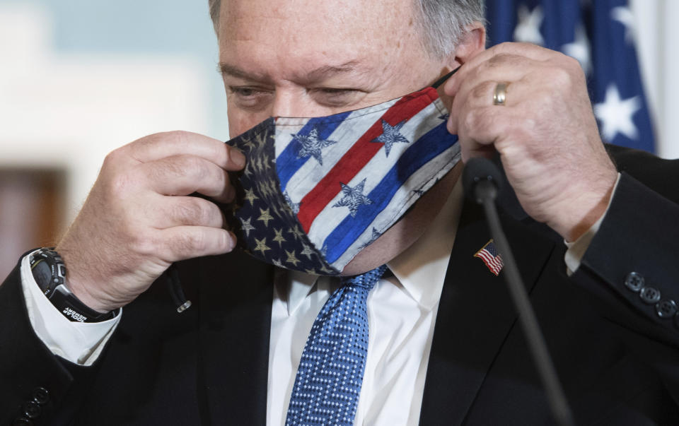 Secretary of State Mike Pompeo puts on his mask after speaking to the media prior to meeting with Kuwaiti Foreign Minister Sheikh Ahmad Nasser Al-Mohammad Al-Sabah at the State Department, Tuesday, Nov. 24, 2020 in Washington. (Saul Loeb/Pool via AP)