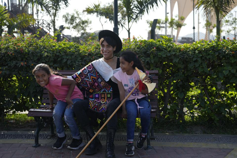 Peruvian musician Lenin Tamayo jokes with young fans while taking a break from recording a video in downtown Lima, Peru, Thursday, Aug. 3, 2023. With his fusion of K-pop and Andean culture, the 23-year-old composer is known as the inventor of Quechua pop or Q-pop, writing songs in Spanish and Quechua. (AP Photo/Martin Mejia)