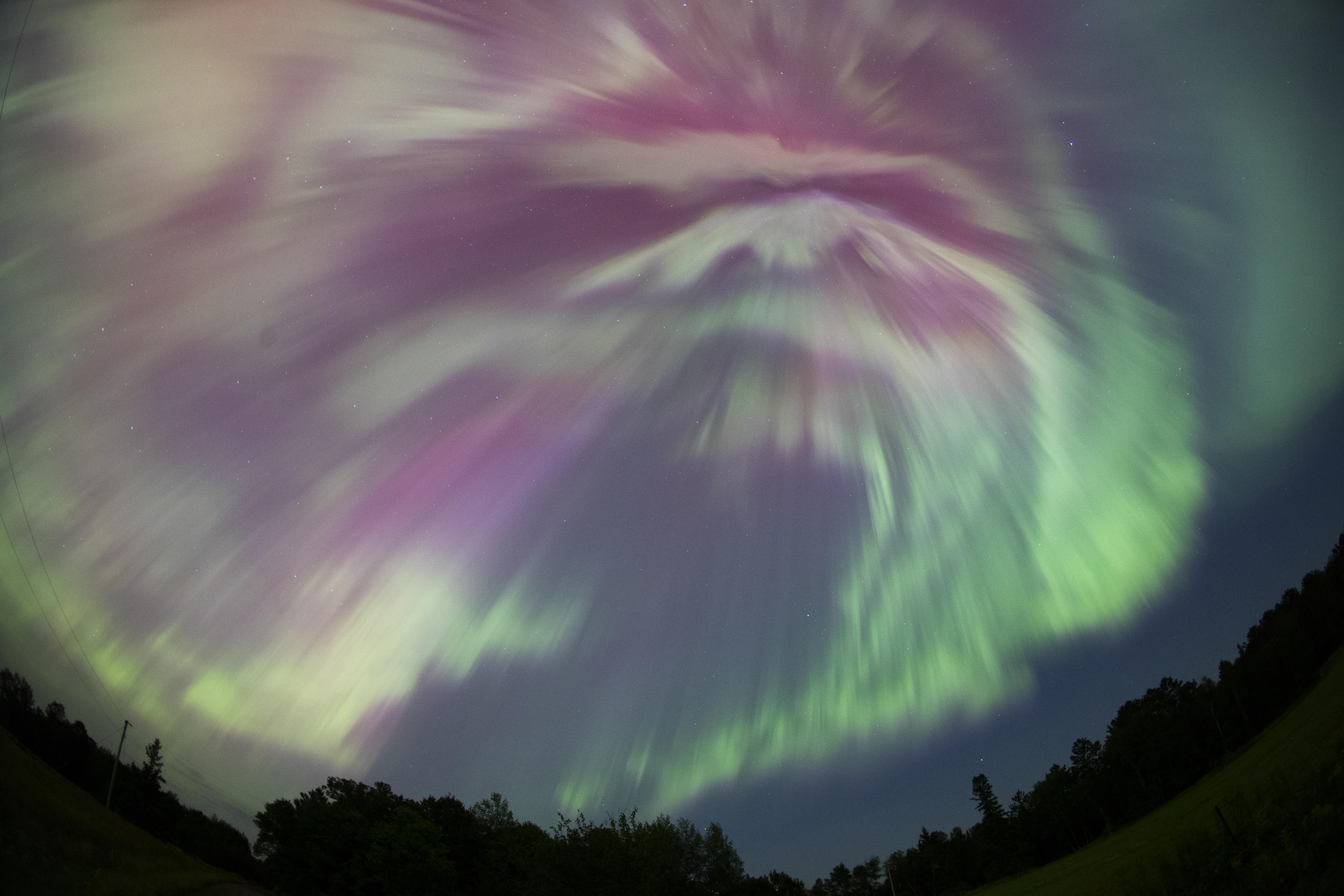 Burza geomagnetyczna wytwarza żywe zielone i różowe kolory podczas szczytu roju meteorów Perseidów w Aitkin w stanie Minnesota.