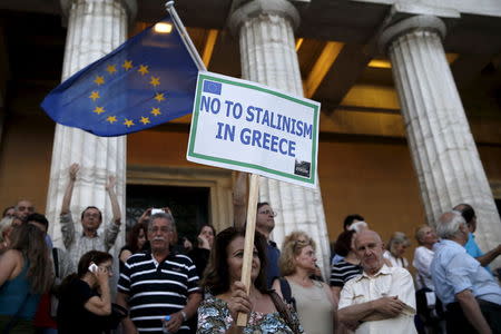 A woman holds a placard as people gather at the entrance of the Greek parliament after entering its premises, during a rally calling on the government to clinch a deal with its international creditors and secure Greece's future in the Eurozone, in Athens June 18, 2015. REUTERS/Yannis Behrakis