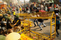 NEW DELHI, INDIA - JANUARY 26: Indian Farmers attempt to break a barricade farmers who marched to the capital during India's Republic Day celebrations in New Delhi on India January 26, 2021, The thousands of farmers drove a convoy of tractors into the Indian capital as the nation celebrated Republic Day on Tuesday in the backdrop of agricultural protests that have grown into a rebellion and rattled the government. (Photo by Imtiyaz Khan/Anadolu Agency via Getty Images)