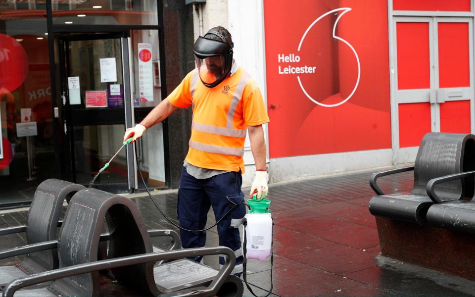 A council worker sprays street furniture with disinfectant during lockdown on July 01, 2020 in Leicester - Getty Images