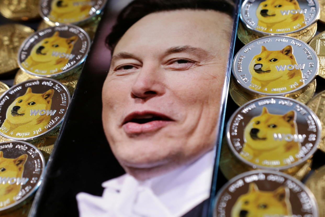 A photo of Elon Musk is displayed on a smartphone placed on representations of cryptocurrency Dogecoin.