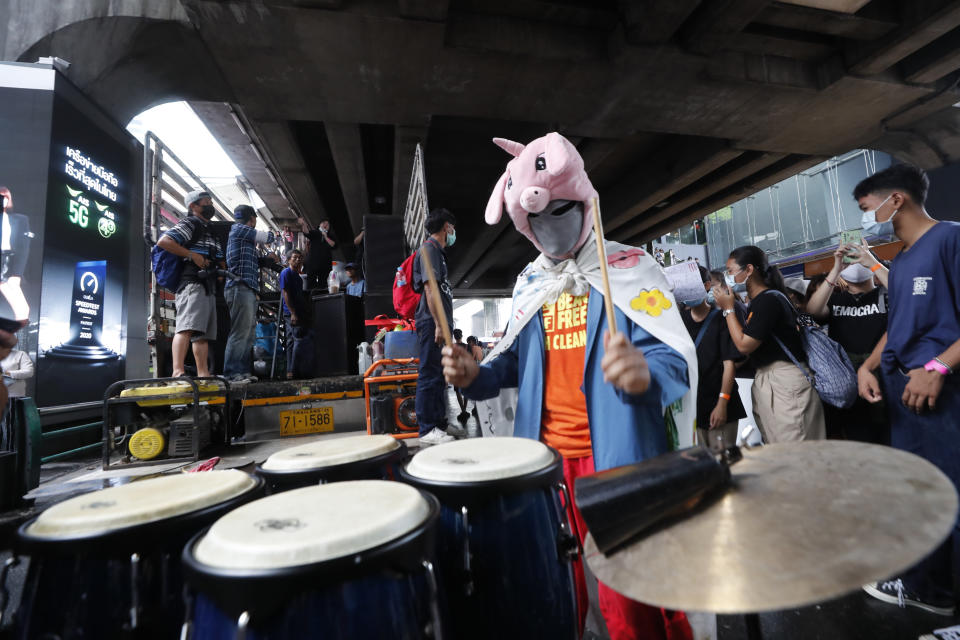 An individual wearing a mask beats conga drums during a student rally in Bangkok, Saturday, Nov. 21, 2020. Organized by a group that mockingly calls themselves "Bad Students," the rally calls for educational reforms and also supports the broader pro-democracy movement's demands for constitutional change. (AP Photo/Sakchai Lalit)