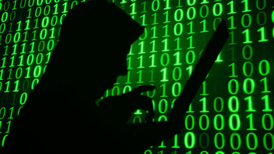 <div>Computer hacker silhouette. Green binary code background</div>