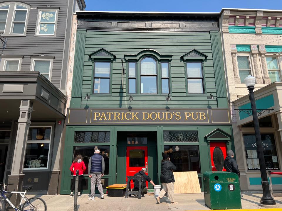 Passersby stop to look into the window of Patrick Doud's Irish Pub on Wednesday, May 17, 2023 on Mackinac Island. Co-owned by Andrew Doud, the pub is named after his great uncle and opened this season.