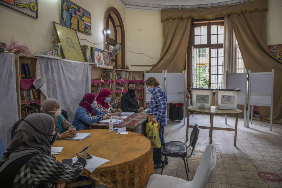 A woman prepares to vote on the first day in the second and final stage of the country's parliamentary elections in Cairo, Egypt, Saturday, Nov. 7, 2020. Egyptians began voting on Saturday after a relatively low turnout in the first stage that embarrassed the government of President Abdel-Fattah el-Sissi. (AP Photo/Nariman El-Mofty)