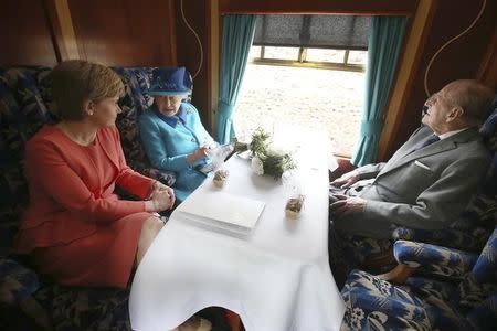 Britain's Queen Elizabeth travels with Prince Philip and Scotland's First Minister Nichola Sturgeon (L) on the new Scottish Borders railway line, in Scotland, September 9, 2015. REUTERS/Andrew Milligan/Pool