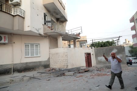 A man reacts after an apartment building hit by a rocket fired from Syria, in Nusaybin