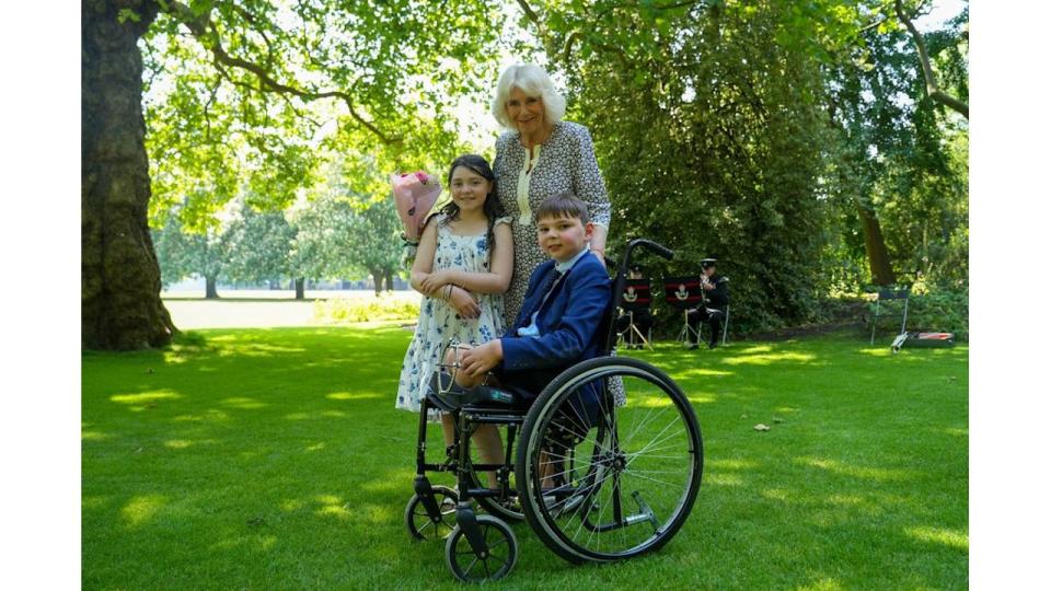 Queen Camilla with a young girl and a young boy in a wheelchair