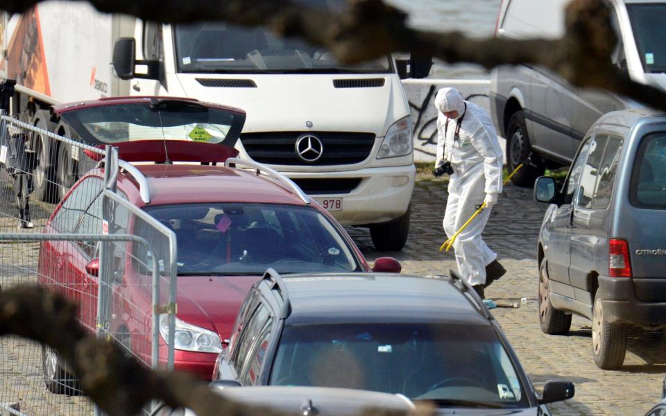 A forensics expert stands next to the car stopped by police in Antwerp  - Credit: Reuters