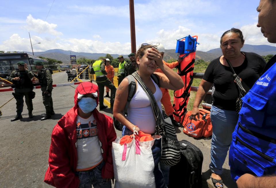 A Colombian woman cries as she arrives with her family at the Simon Bolivar bridge border with Venezuela, in Villa del Rosario village, Colombia