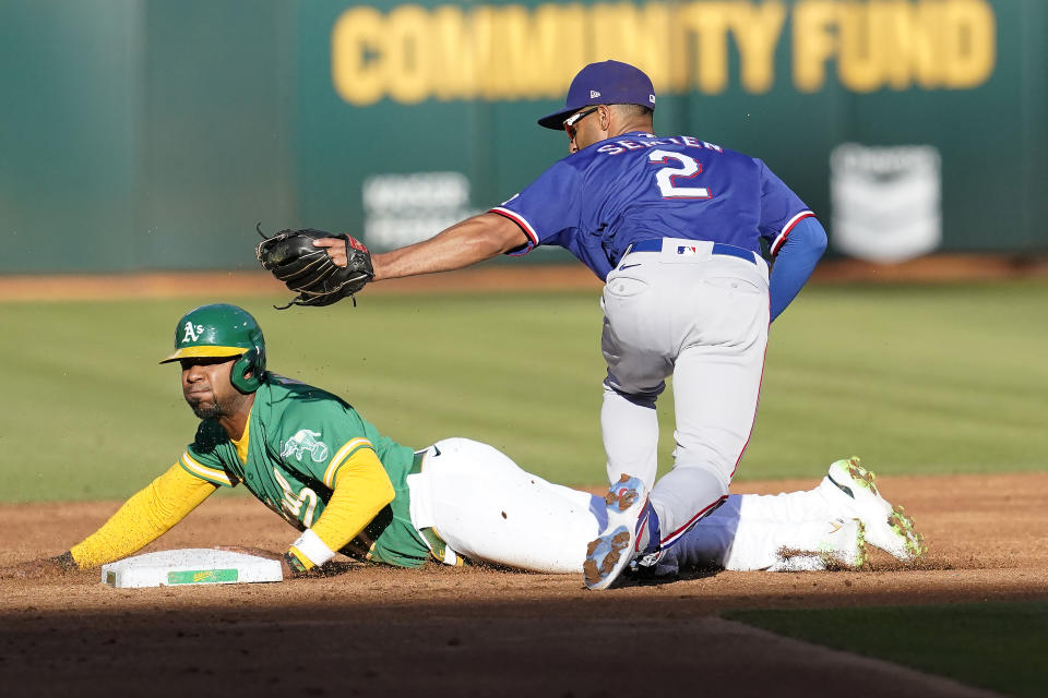 Oakland Athletics' Elvis Andrus, left, is tagged out by Texas Rangers second baseman Marcus Semien (2) while trying to steal second base during the second inning of a baseball game in Oakland, Calif., Saturday, July 23, 2022. (AP Photo/Jeff Chiu)