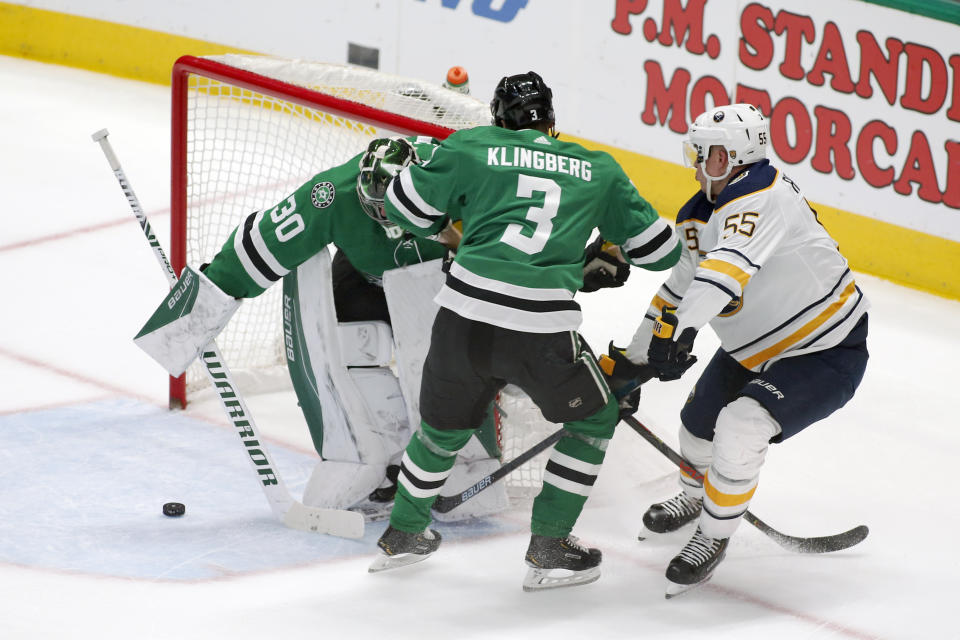 Dallas Stars goaltender Ben Bishop, left, clears the puck as defenseman John Klingberg (3) and Buffalo Sabres defenseman Rasmus Ristolainen (55) look for the rebound during the first period of an NHL hockey game in Dallas, Thursday, Jan. 16, 2020. (AP Photo/Ray Carlin)