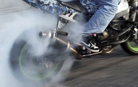 A member of the motorcycle stunt group Team Myrtle West burns out a tire at the 2012 Atlantic Beach Bikefest in Atlantic Beach, South Carolina in this May 25, 2012 file photo. REUTERS/Randall Hill/Files