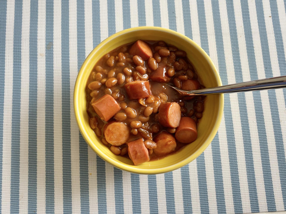 bowl of baked beans with cut up hot dogs