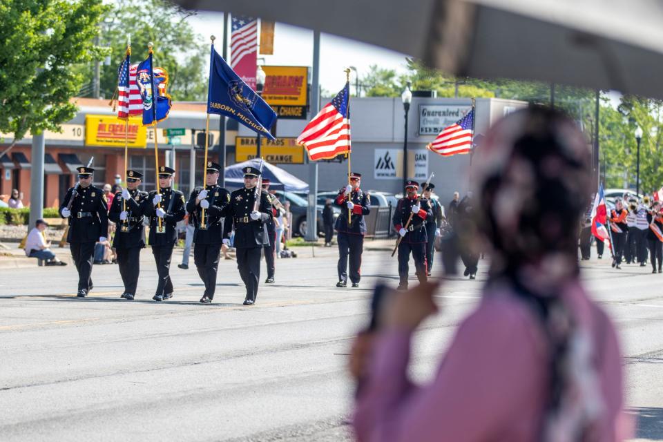 Parade attendees watch Dearborn police march during the 96th Memorial Day Parade along Michigan Avenue in Dearborn on Monday, May 30, 2022. The parade returned after a two year hiatus due to the pandemic.