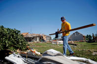 Alex Wills of Mazon helps his uncle clean up his property on W. Daisy Place on June 23, 2015 after a tornado struck the previous day in Coal City, Illinois. The National Weather Service has confirmed that at least five tornadoes touched down in north central Illinois, causing widespread damage and power outages. (Photo by Jon Durr/Getty Images)
