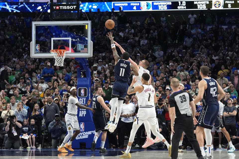 Dallas Mavericks guard Kyrie Irving (11) shoots the winning final-second basket against Denver Nuggets center Nikola Jokic, top center right, in an NBA basketball game in Dallas, Sunday, March 17, 2024. (AP Photo/LM Otero)