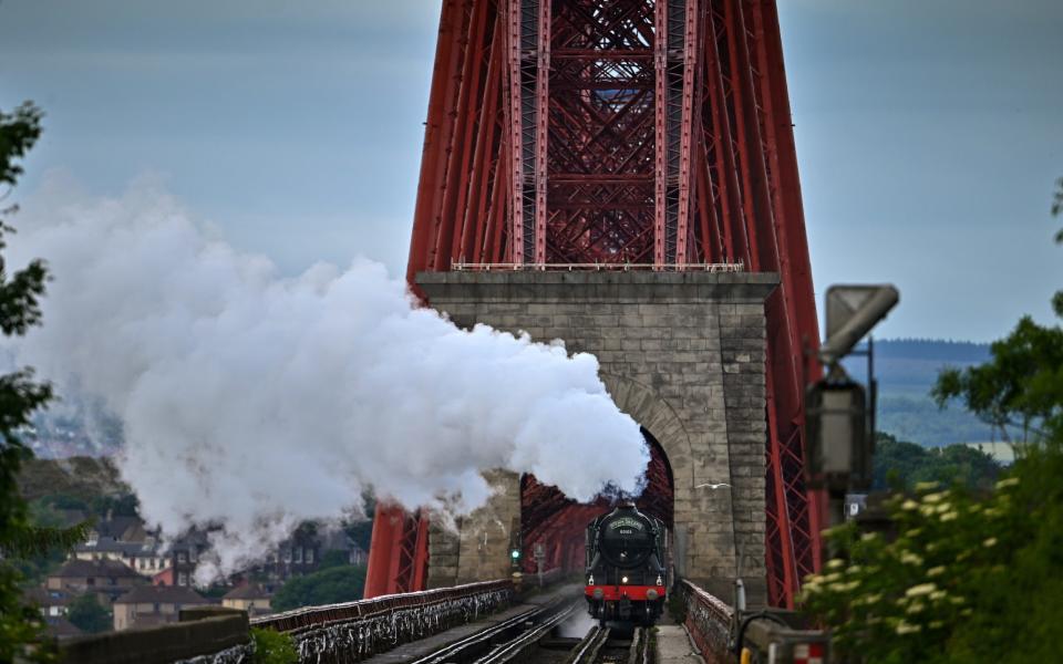 The Flying Scotsman steam train travels across the Forth Bridge, after making a journey through Fife