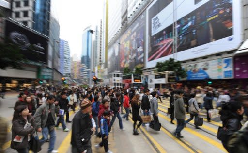 This file photo shows people crossing a street in Causeway Bay, one of Hong Kong's busiest retail districts. Causeway Bay has knocked New York's Fifth Avenue off the top of the list of most expensive places to rent retail space in the world, according to the latest research