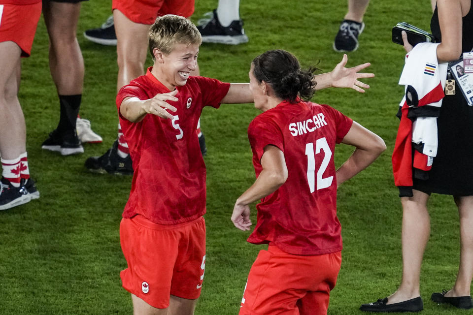 Canada's Quinn, left, and Canada's Christine Sinclair celebrate after beating Sweden in a penalty shootout during the women's soccer match for the gold medal at the 2020 Summer Olympics, Friday, Aug. 6, 2021, in Yokohama, Japan. (AP Photo/Kiichiro Sato)