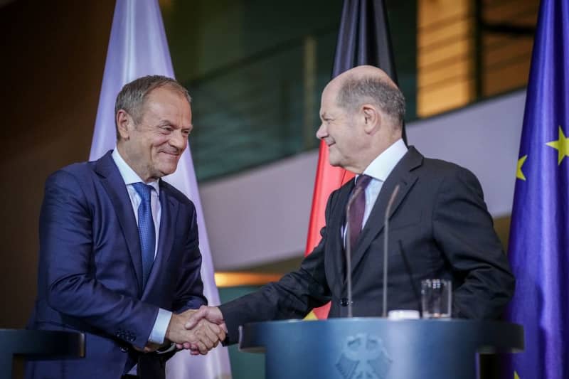 Polish Prime Minister Donald Tusk (L) and German Chancellor Olaf Scholz arrive for a press conference after their meeting at the Federal Chancellery. Kay Nietfeld/dpa