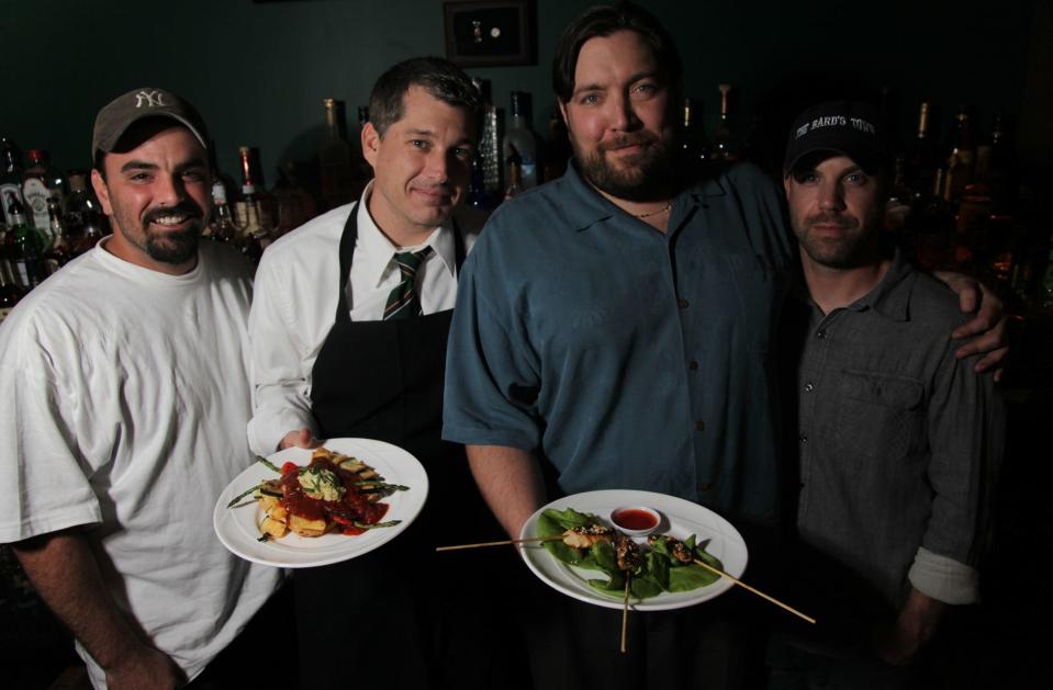 As seen in this 2010 file photo, co-owners Jon DeSalvo, left, Doug Schutte, Chef Joe Gadansky, and co-owner Scot Atkinson stand behind the bar at The Bard's Town in the Highlands.