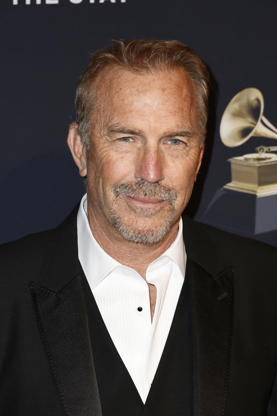 Kevin Costner smiling on a red carpet