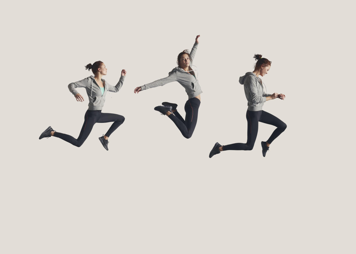 People captured in mid air, while jumping on trampoline in big studio.
