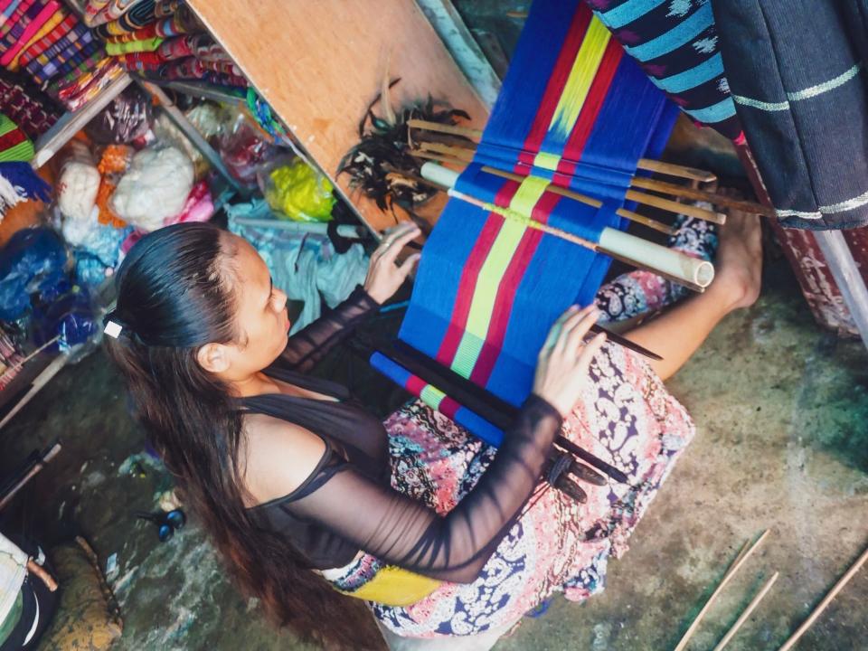 A Timorese woman weaving cloth in a market